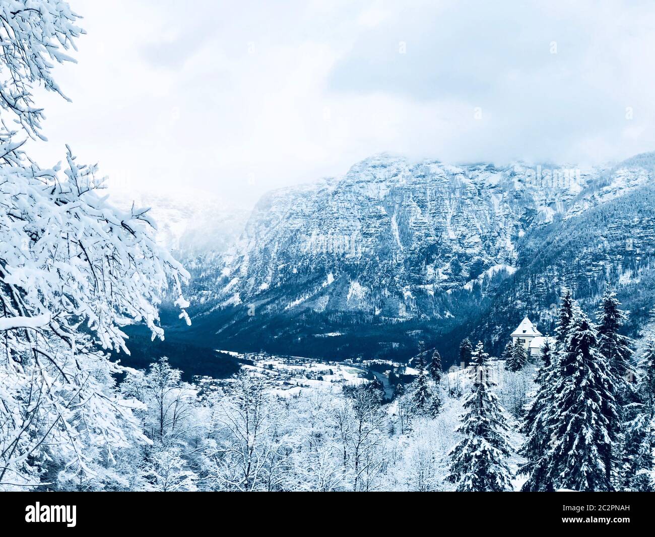 Scenery of Hallstatt Winter snow mountain landscape valley and lake through the forest in upland valley leads to the old salt mine of Hallstatt, Austr Stock Photo