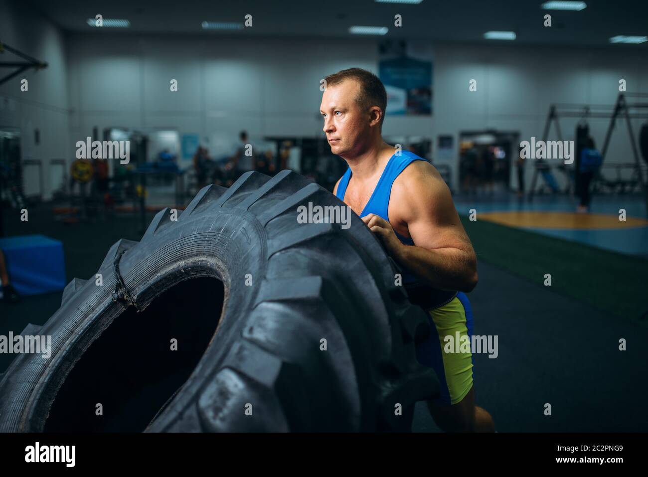 Strong male athlete doing strength exercise with truck tyre in gym crossfit workout. Cross fit training in fitness club Stock Photo Alamy