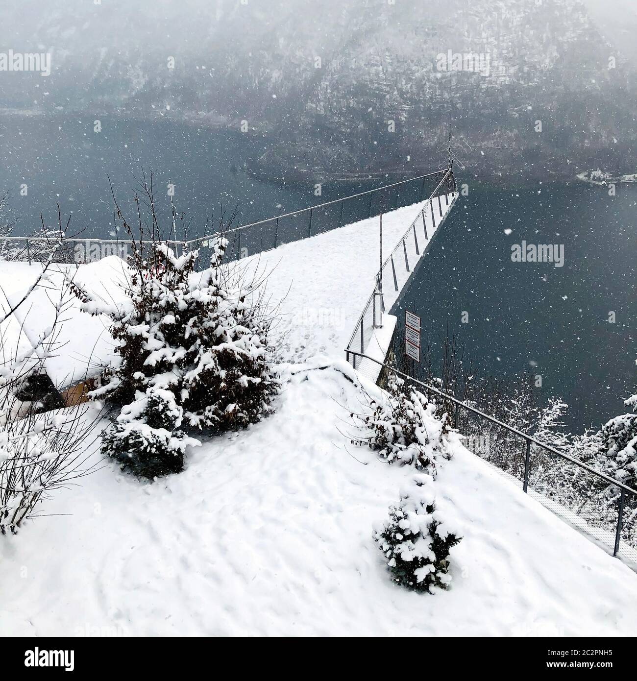 Triangle viewpoint of Hallstatt Winter snow mountain landscape hike epic mountains outdoor adventure and lake through the pine forest in upland valley Stock Photo