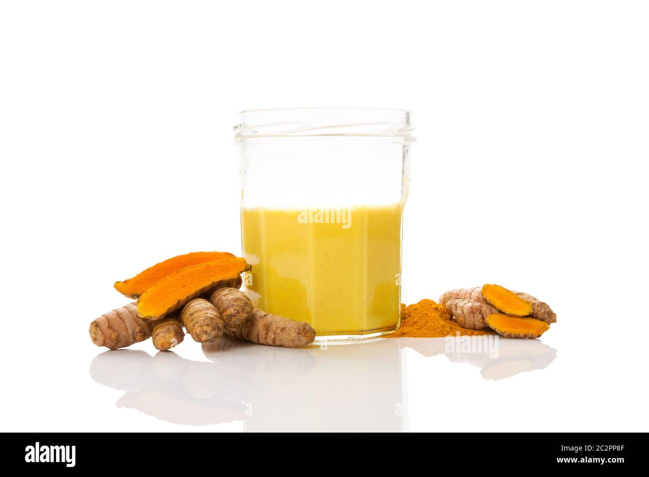 Golden turmeric milk latte with roots on white background. Health and