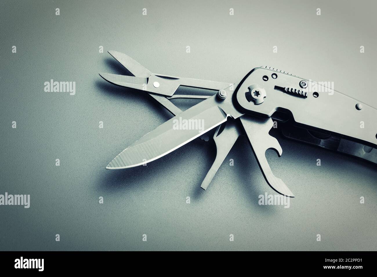 Black opened multitool knife closeup. Toned Stock Photo