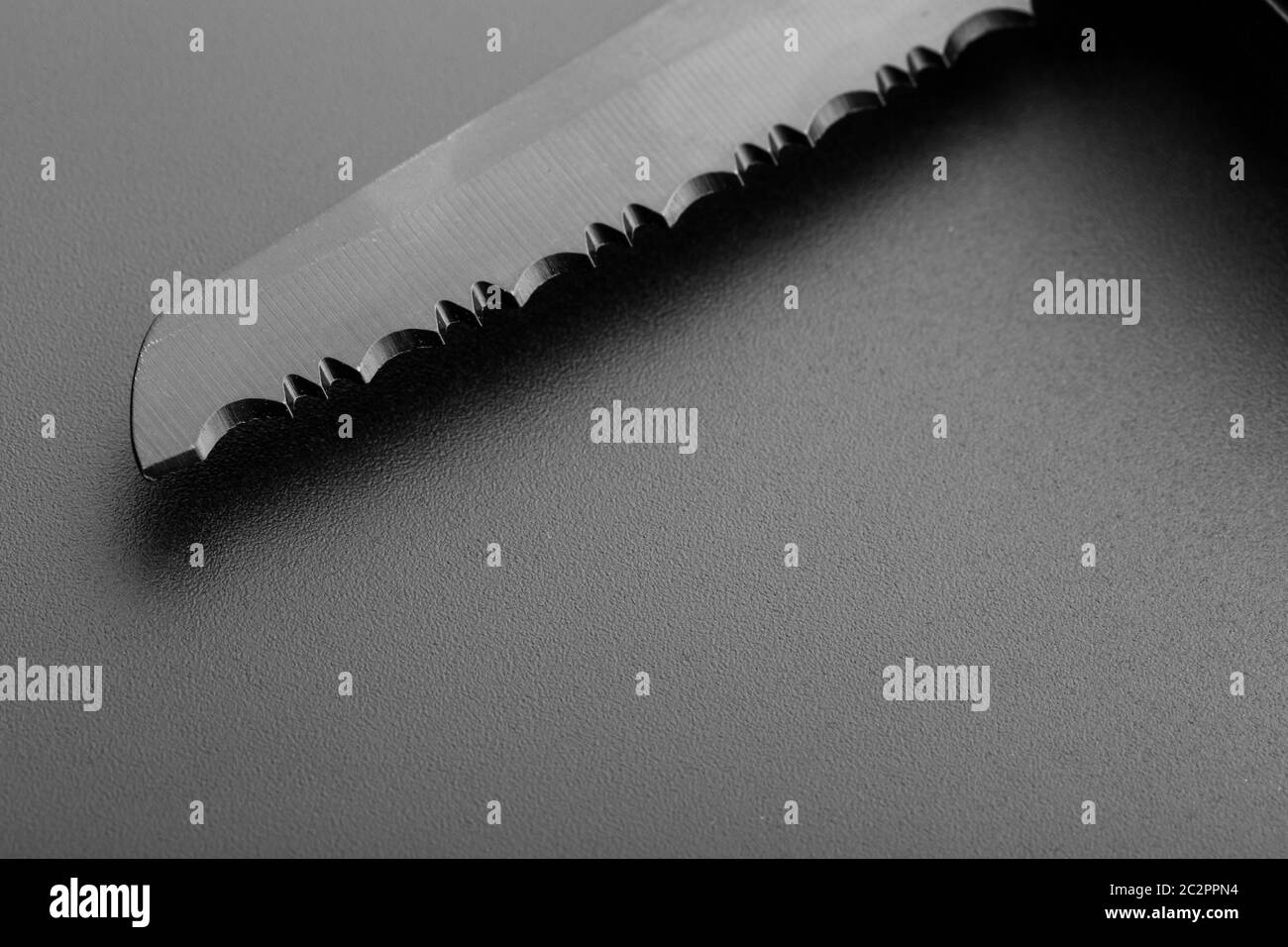 Black serrated knife blade closeup Stock Photo Alamy