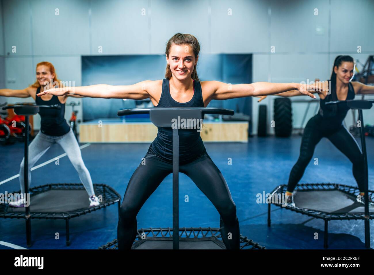 Women on sport trampoline in motion, fitness training. Female teamwork