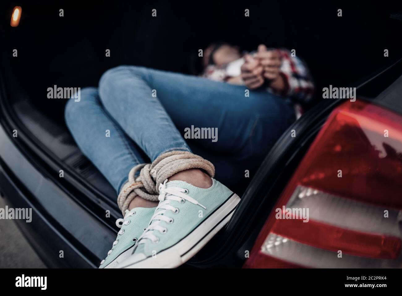 Female victim in car trunk, maniac concept. Duct tape and rope, serial