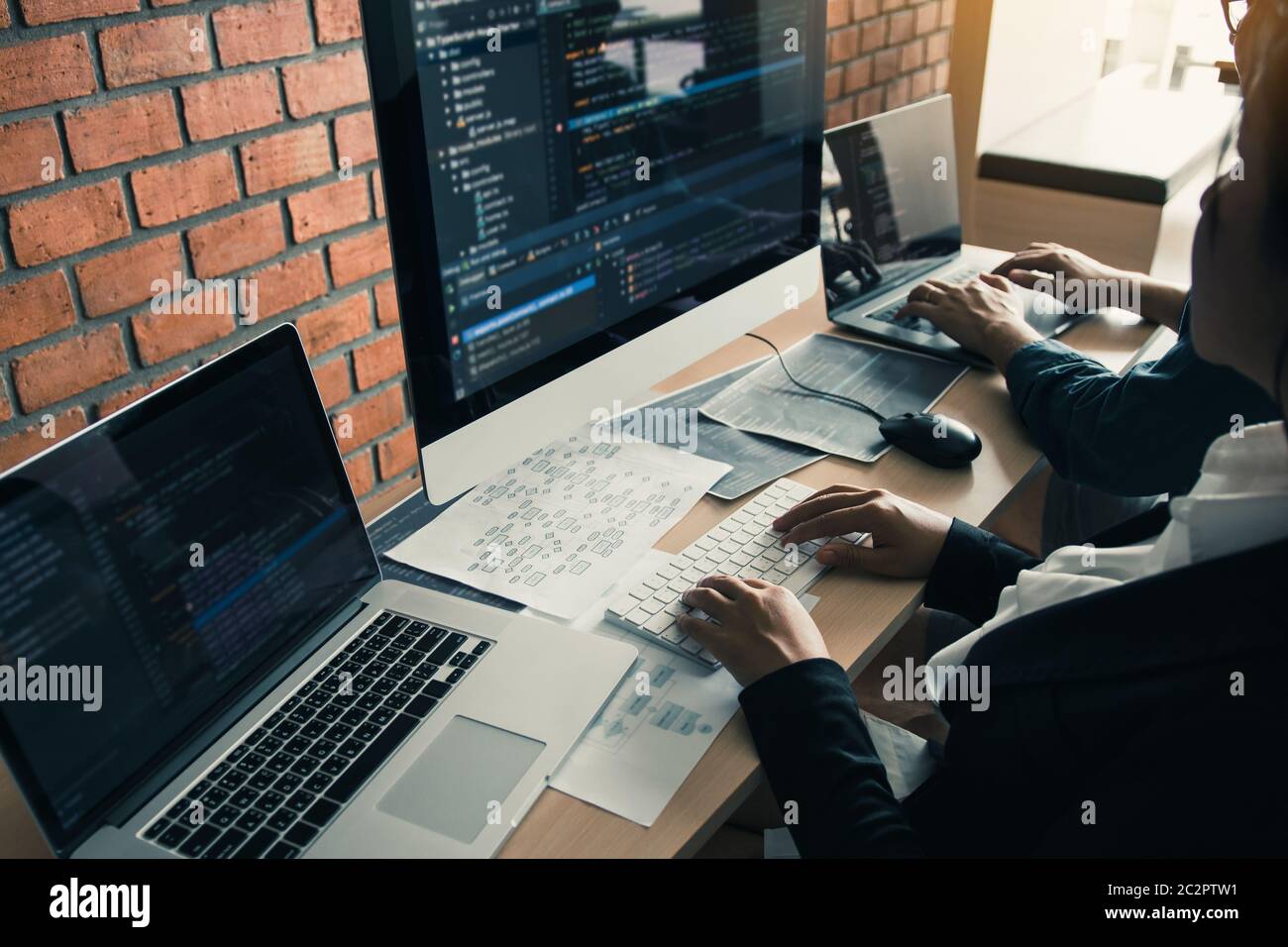 Two partnerships developing programming and coding technologies working on laptop and analyzing together. Stock Photo