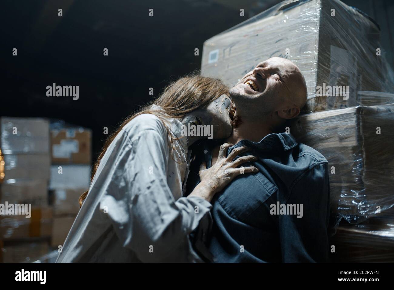 Female zombie bites a man in the neck, death trap, deadly chase. Horror in city, creepy crawlies attack, doomsday apocalypse, bloody monster Stock Photo