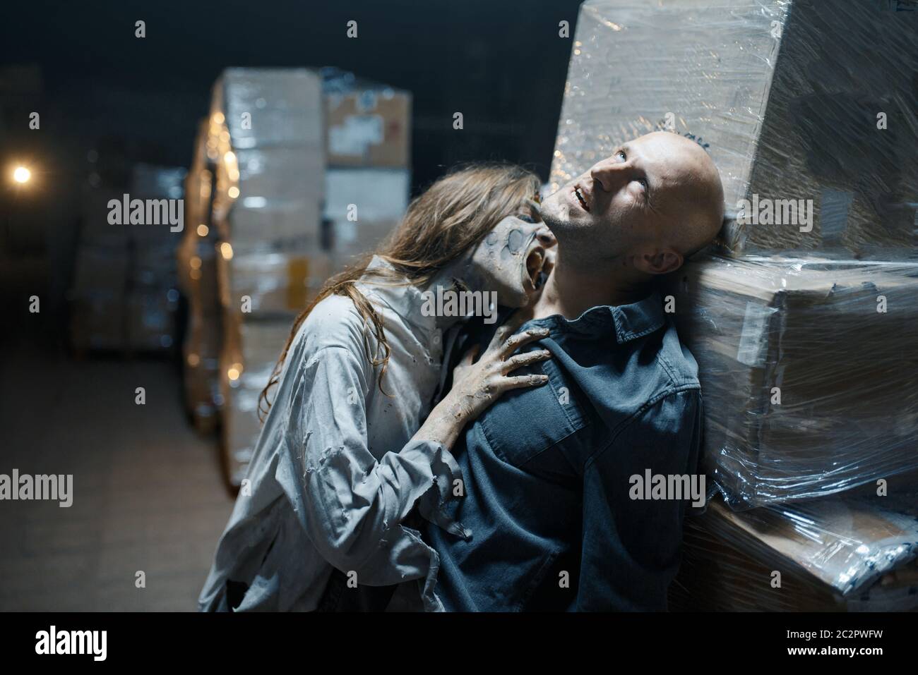 Female zombie bites a man in the neck, death trap, deadly chase. Horror in city, creepy crawlies attack, doomsday apocalypse Stock Photo