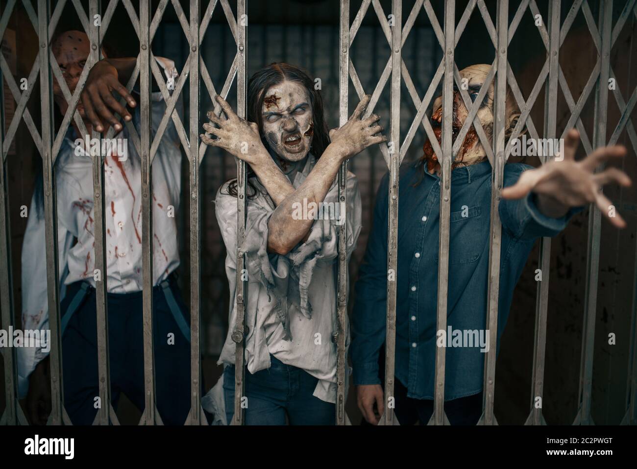 Zombie behind the bars of the elevator, death trap, deadly chase. Horror in city, creepy crawlies attack, doomsday apocalypse, bloody monsters Stock Photo