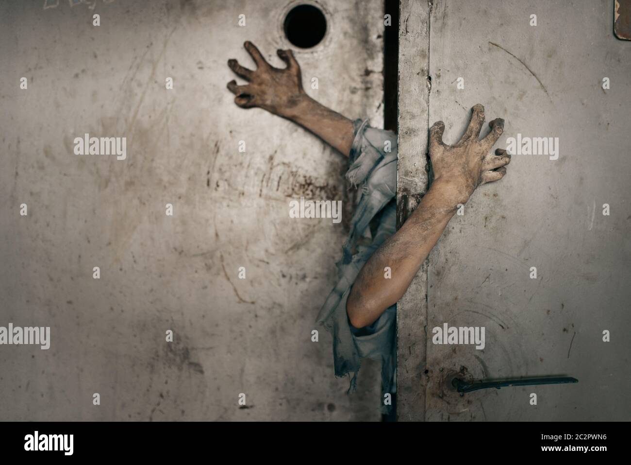 Zombie hands sticking out of the elevator door, deadly chase. Horror in city, creepy crawlies attack, doomsday apocalypse, bloody monsters Stock Photo