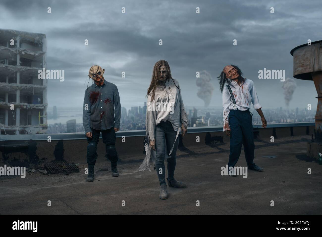 Scary zombie army on the roof of abandoned building, deadly chase. Horror in city, creepy crawlies attack, apocalypse Stock Photo