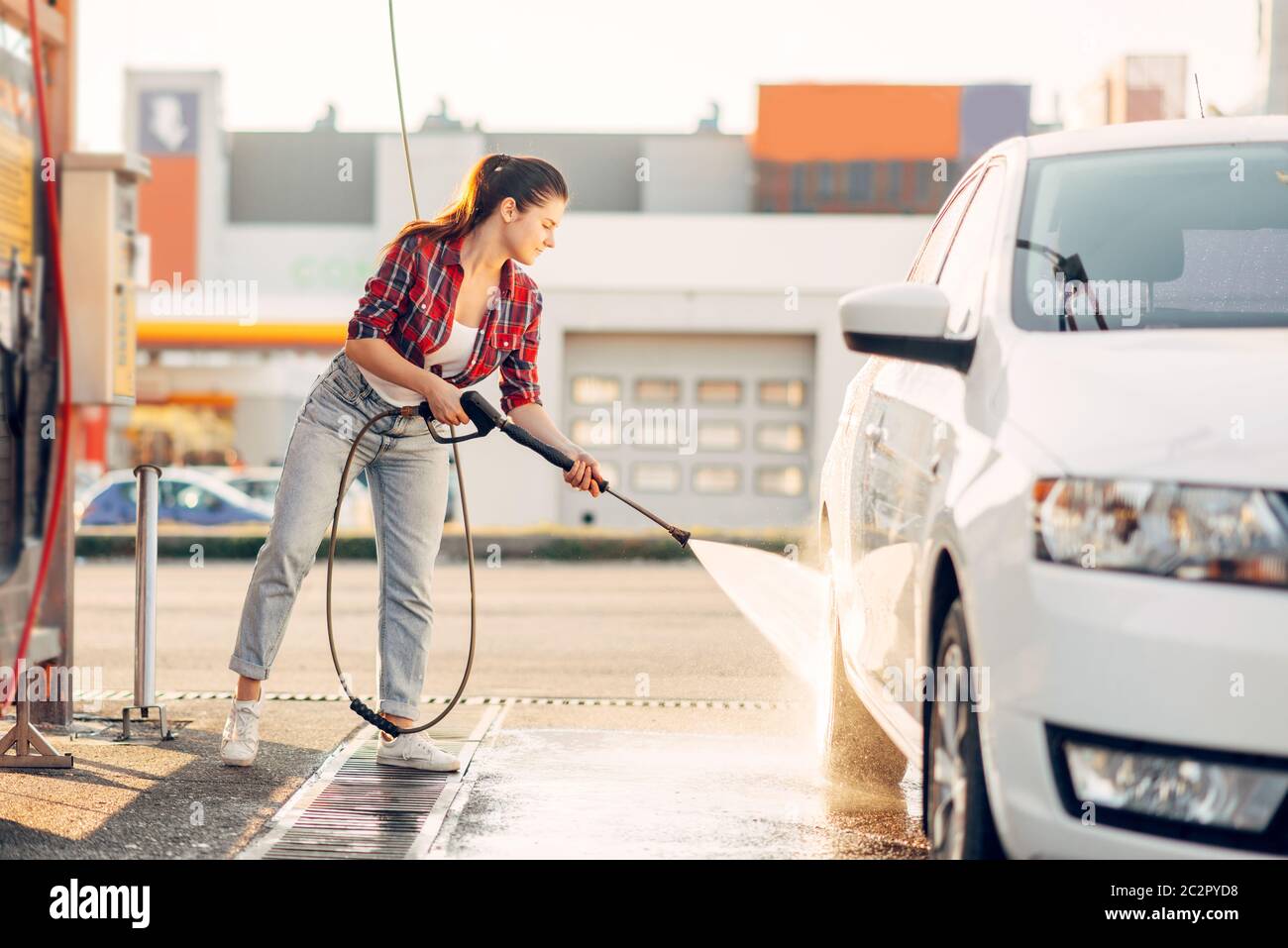 Cute woman with sponge scrubbing vehicle wheel with foam, car wash. Lady on  self-service automobile washing. Outdoor carwash at summer day Stock Photo  - Alamy