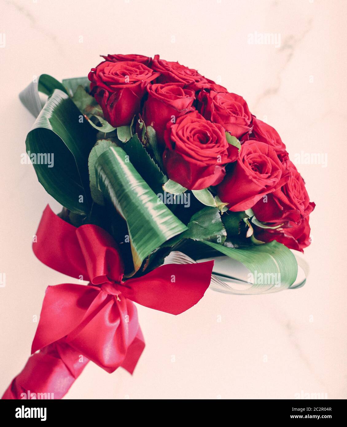 Luxury bouquet of red roses on marble background, beautiful flowers as