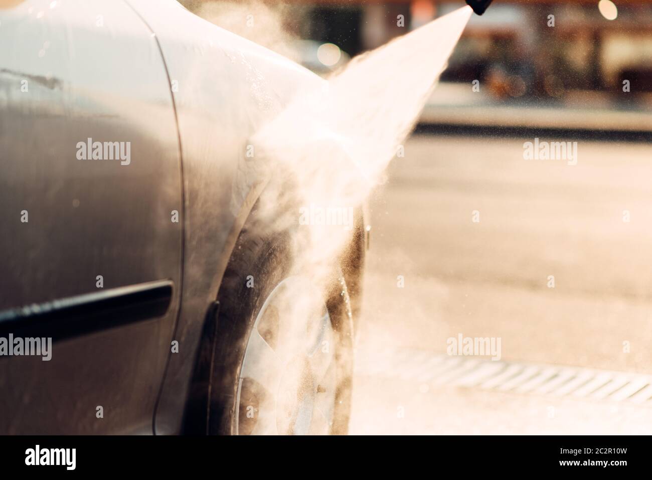High pressure washer, water sprayed from jet. Carwash station. Hand