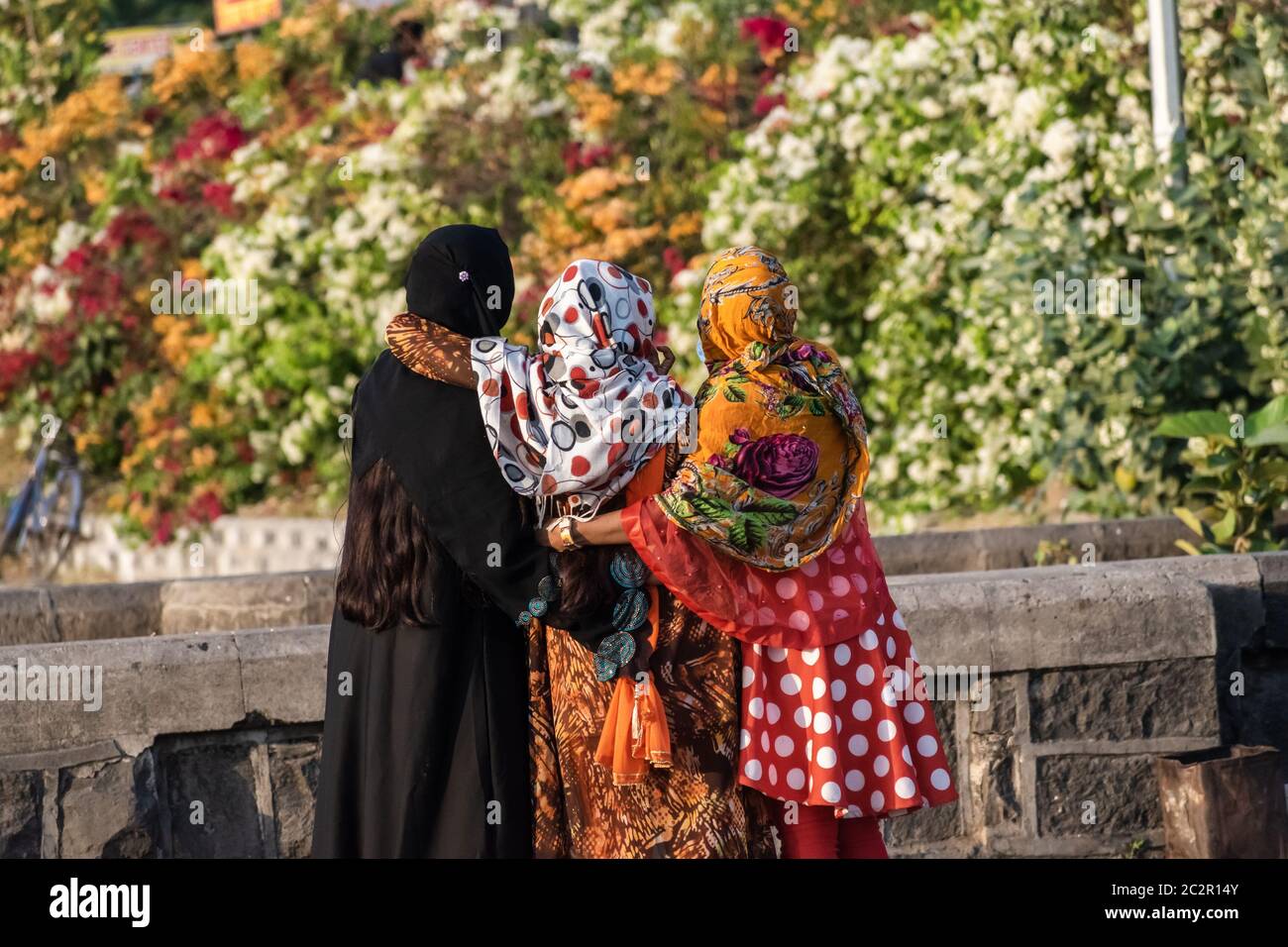 Nagpur, Maharahstra, India - March 2019: Back profile of three young Indian muslim girls wearing black and colourful floral hijabs. Stock Photo
