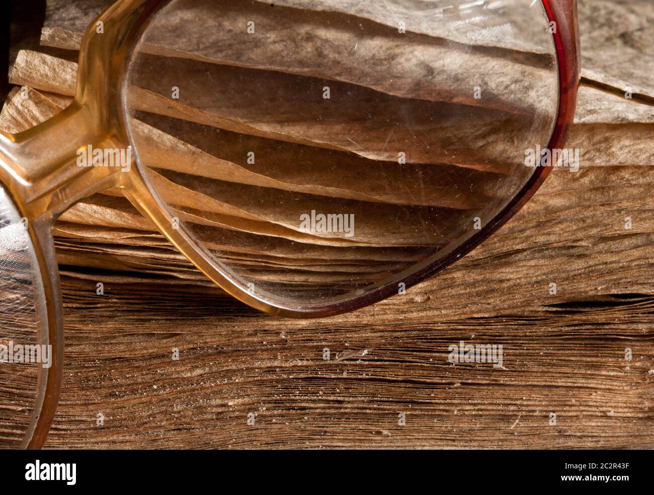 Antique glasses on old weathered book. Close-up view Stock Photo