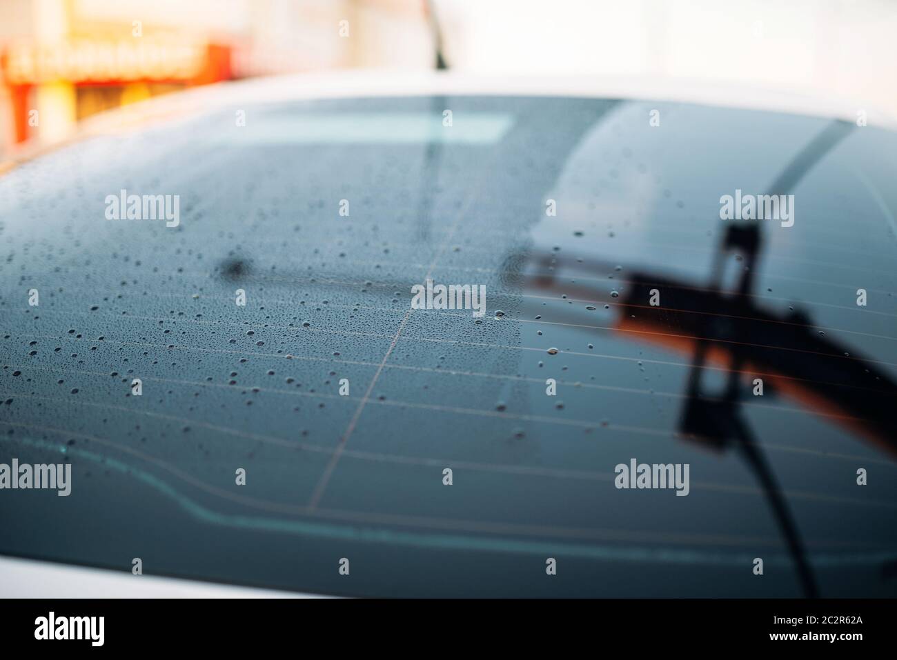 Car rear glass with drops of wax closeup, nobody, waxing process, waterrepellent coating