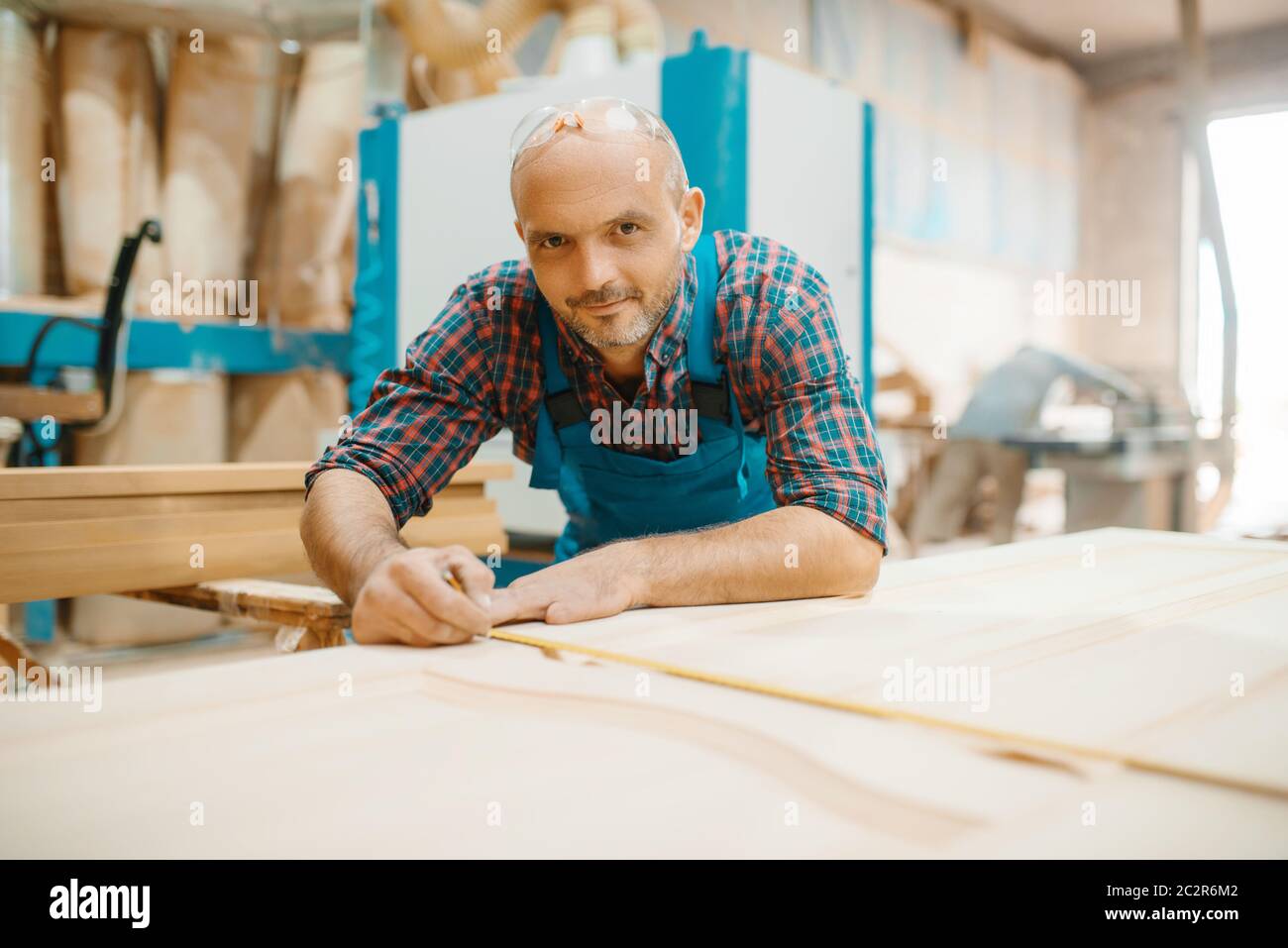 Carpenter processes wooden door, woodworking, lumber industry ...