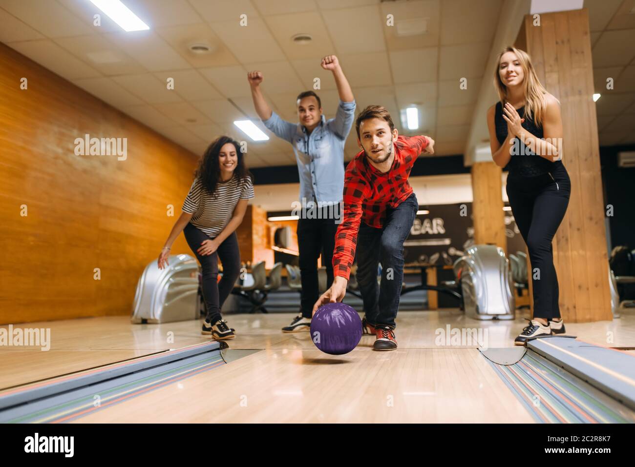 Male bowler throws ball on lane, front view, throwing in action. Bowling alley teams playing the