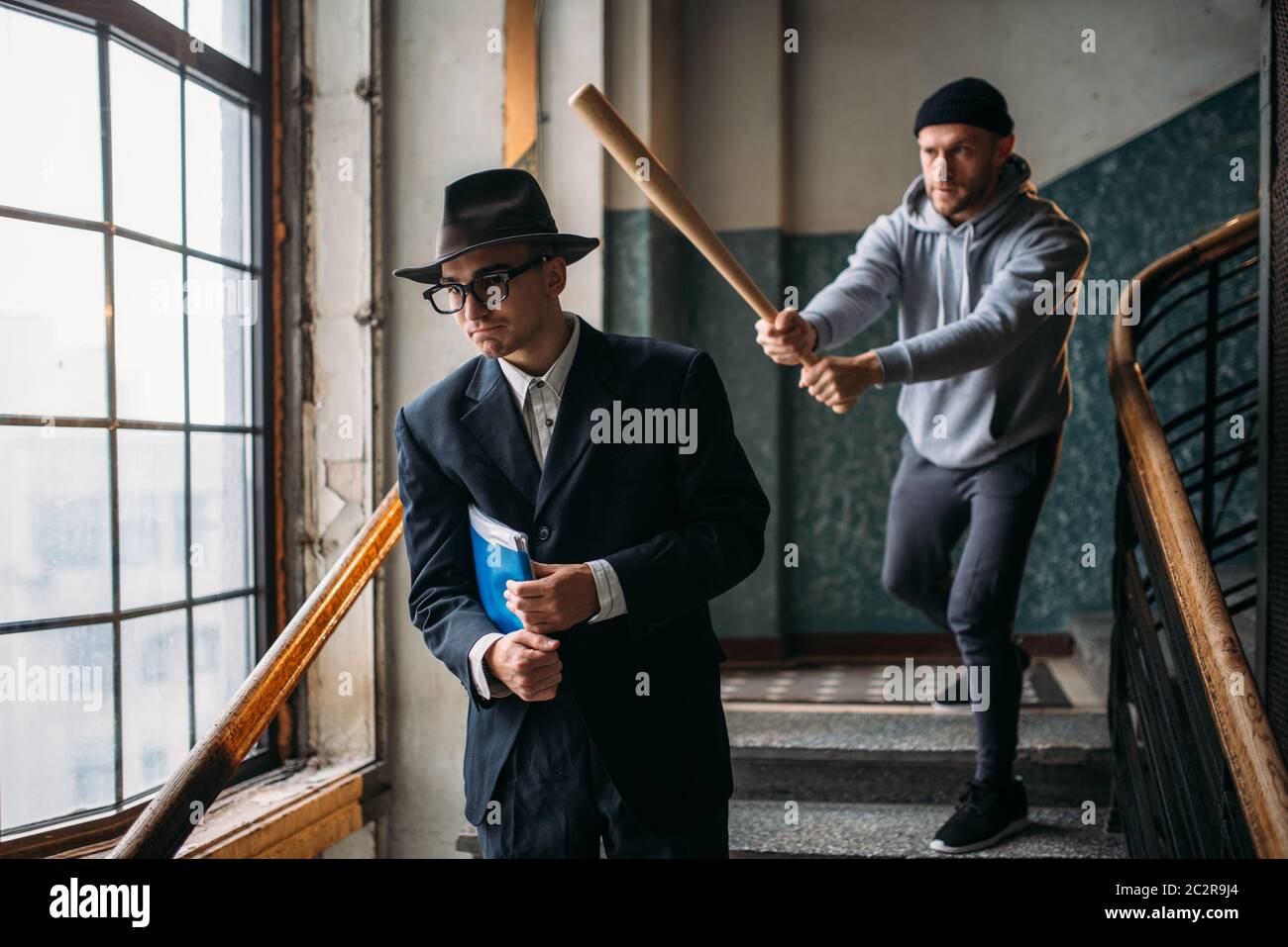 Male bandit with baseball bat attact his victim. Street hooligan commits a  robbery attack on a man. Crime concept Stock Photo - Alamy