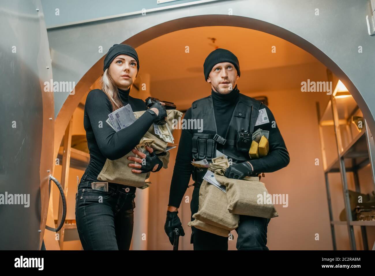 Bank robbery, two robbers with money left the vault. Criminal profession, theft concept, male and female burglars Stock Photo