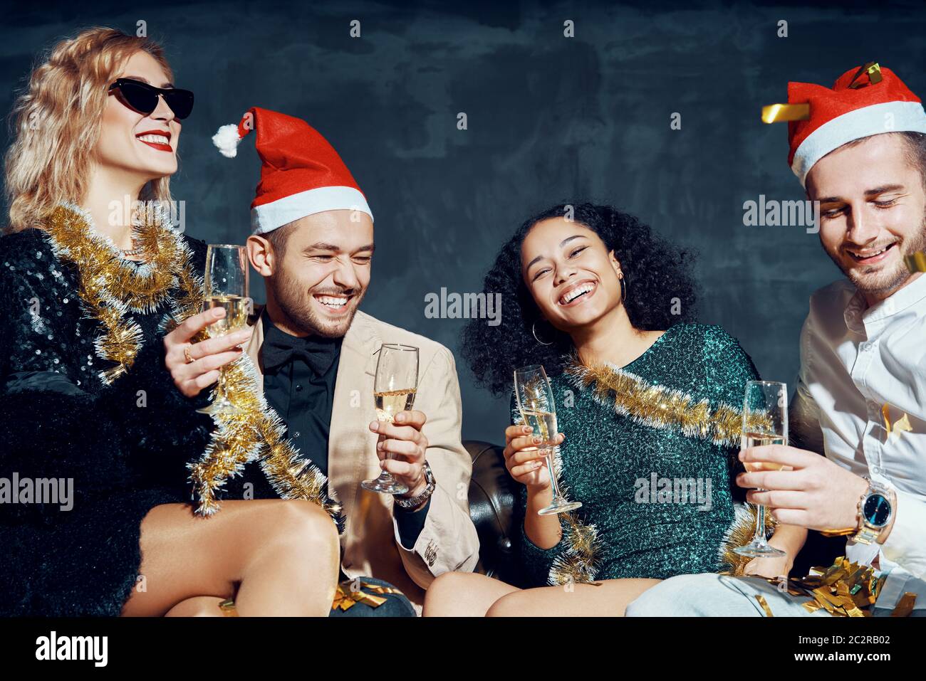 Group of happy smiling friends celebrate New Year together, having fun and drinking champagne Stock Photo