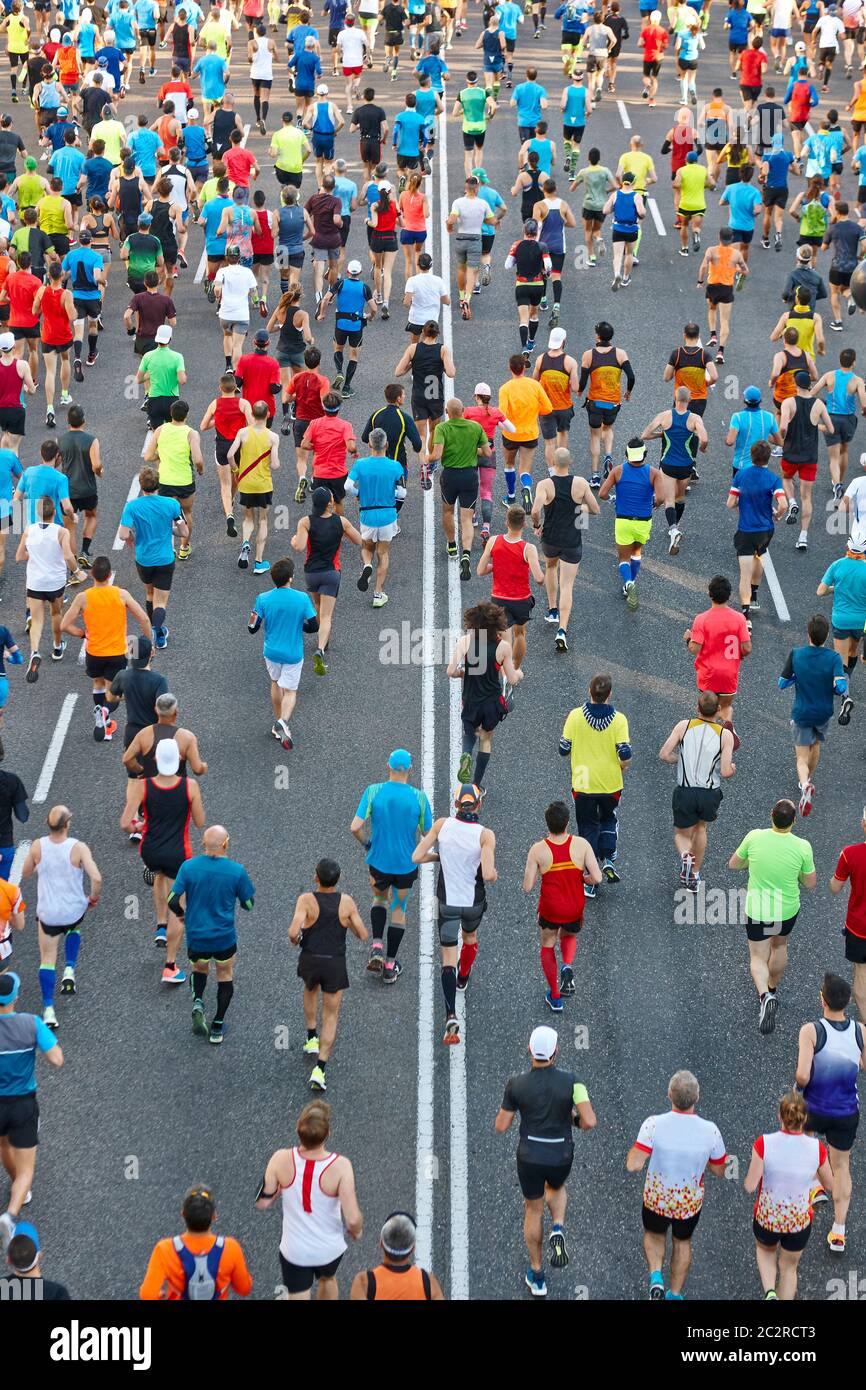 Runners on the street. Athletes in motion. Urban competition. Vertical ...