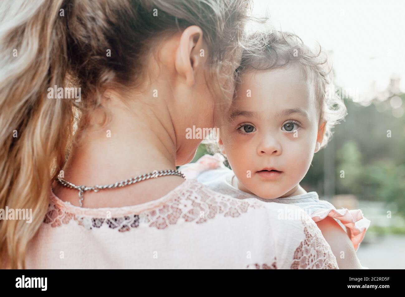 Portrait of a young girl being held by his mother Stock Photo