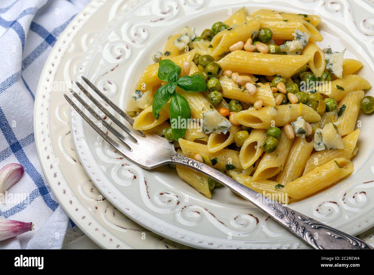 Penne pasta with green peas close up. Stock Photo