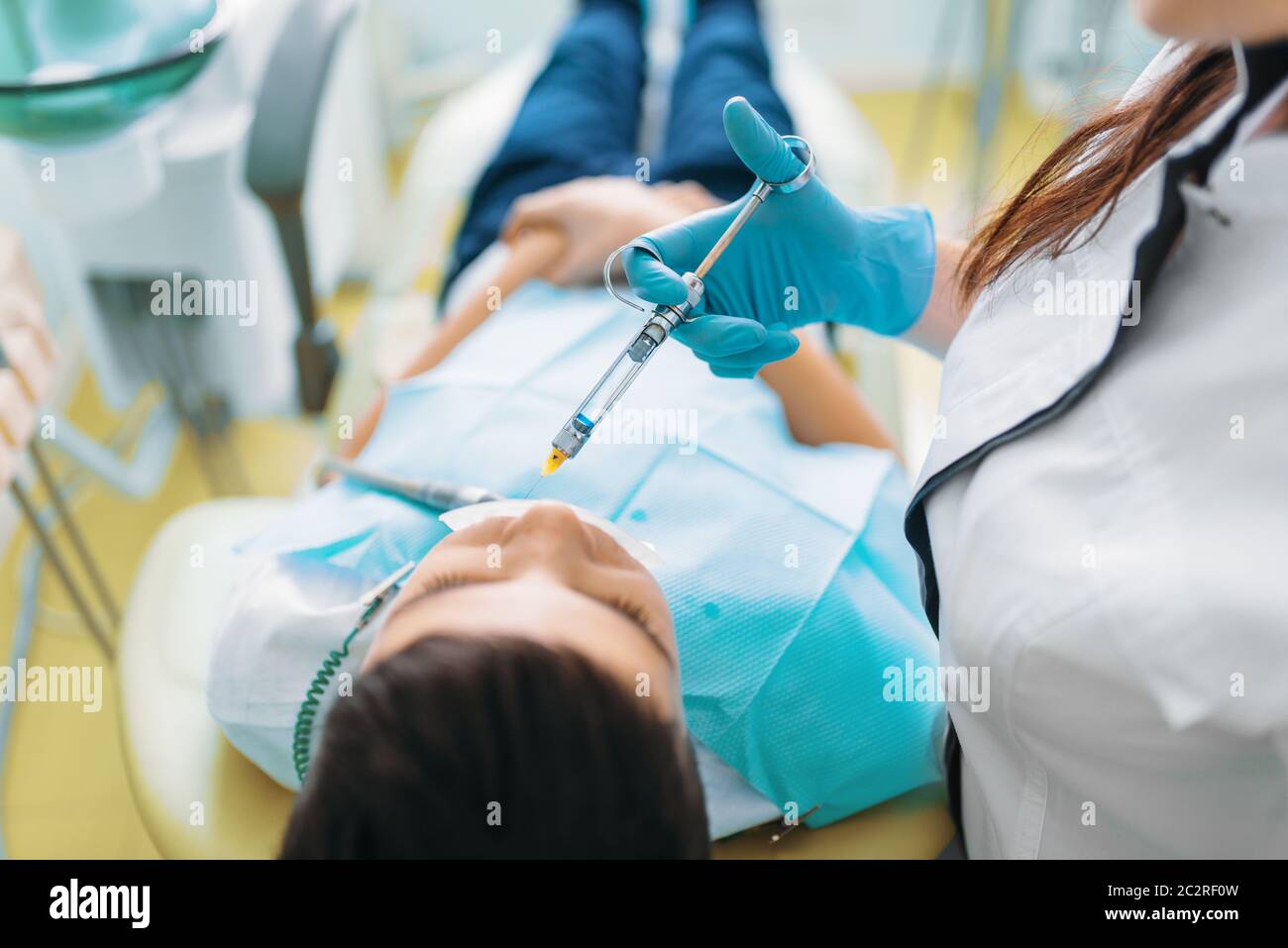 Injection of anesthesia, boy in dental chair, pediatric dentistry
