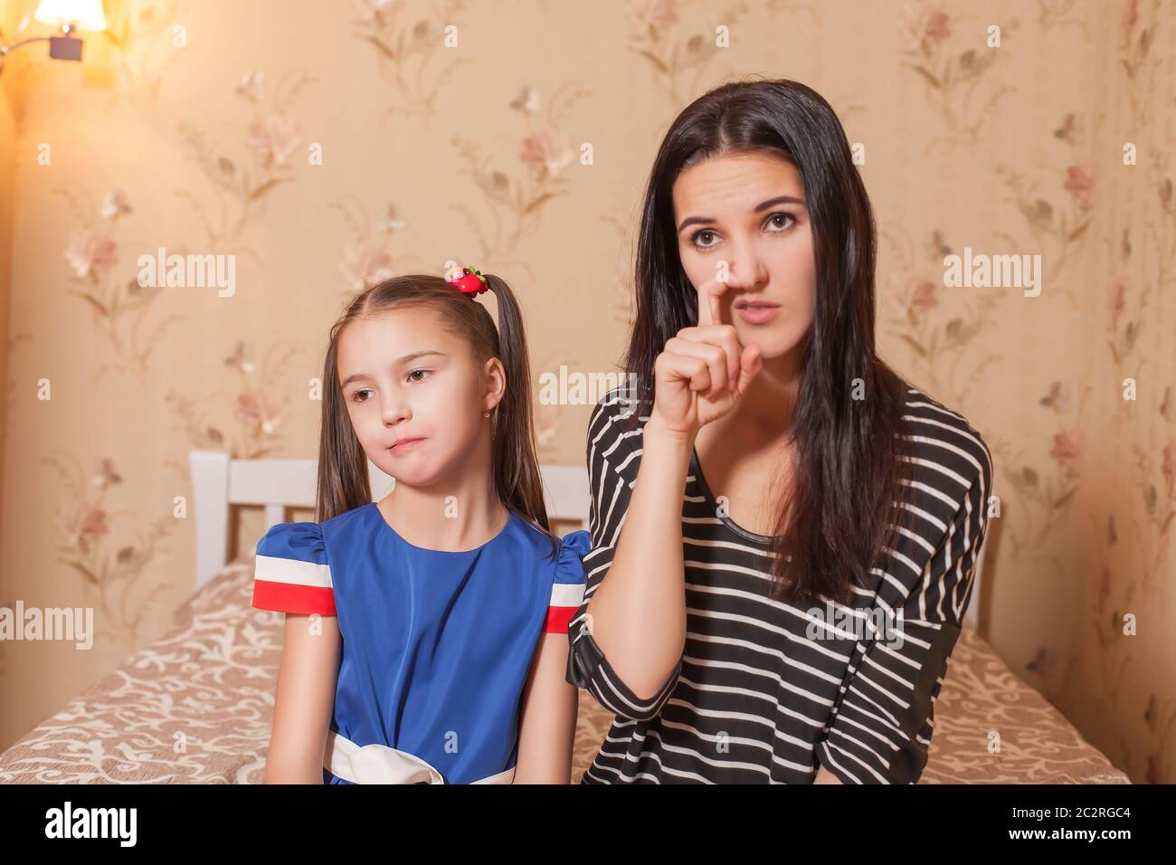 Mother picking a nose against her pretty daughter. Stock Photo