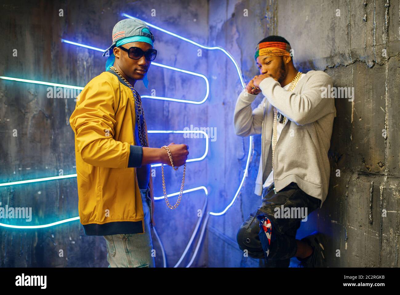 Two black rappers, neon lights on background. Rap performers in subway ...
