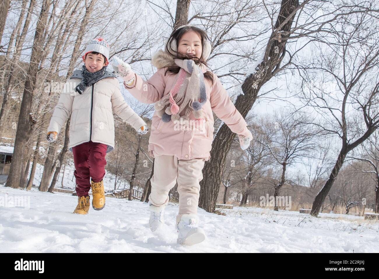 Two children playing in the snow Stock Photo - Alamy