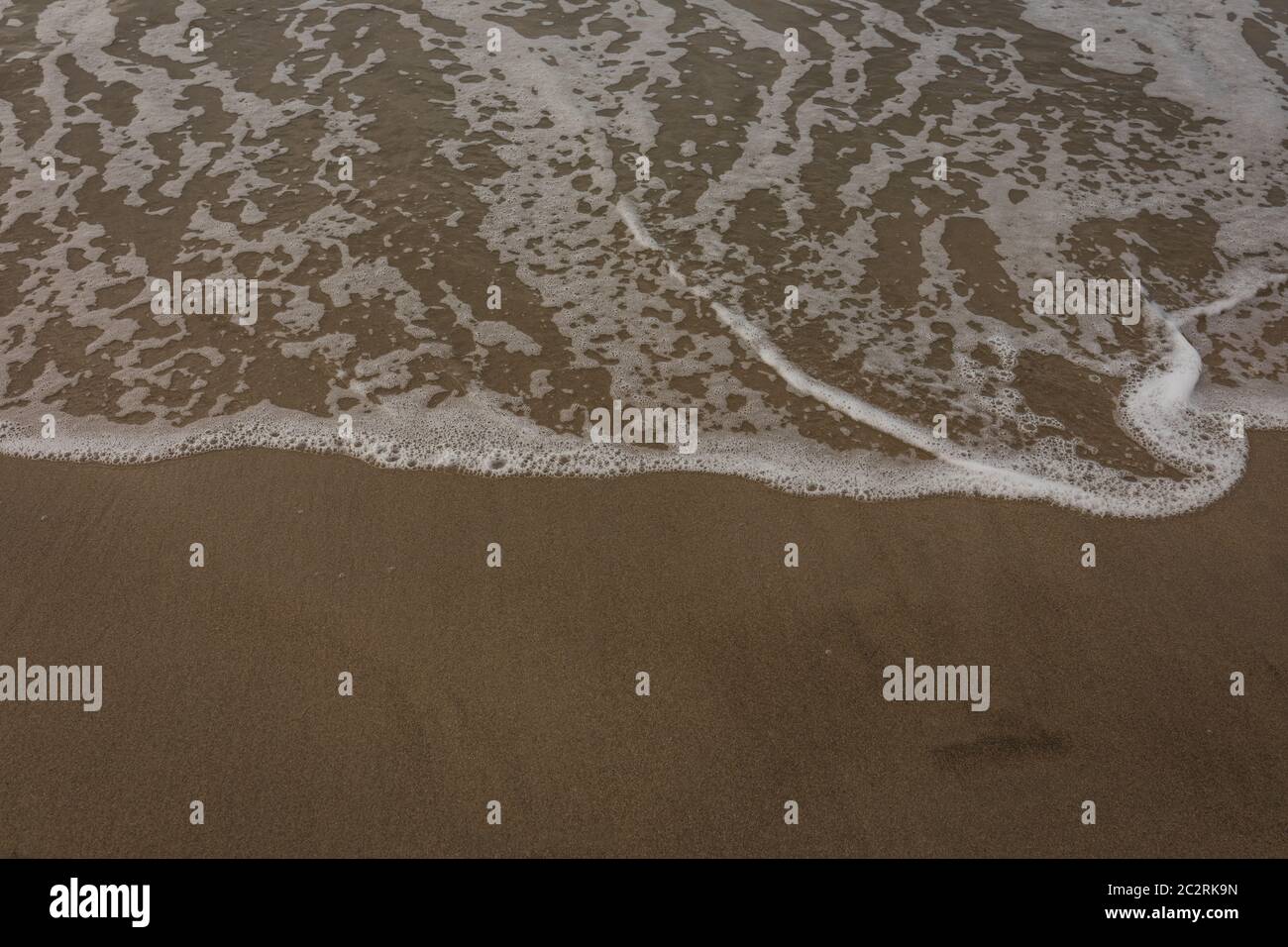 White foam on waves coming to shore on summer beach Stock Photo Alamy