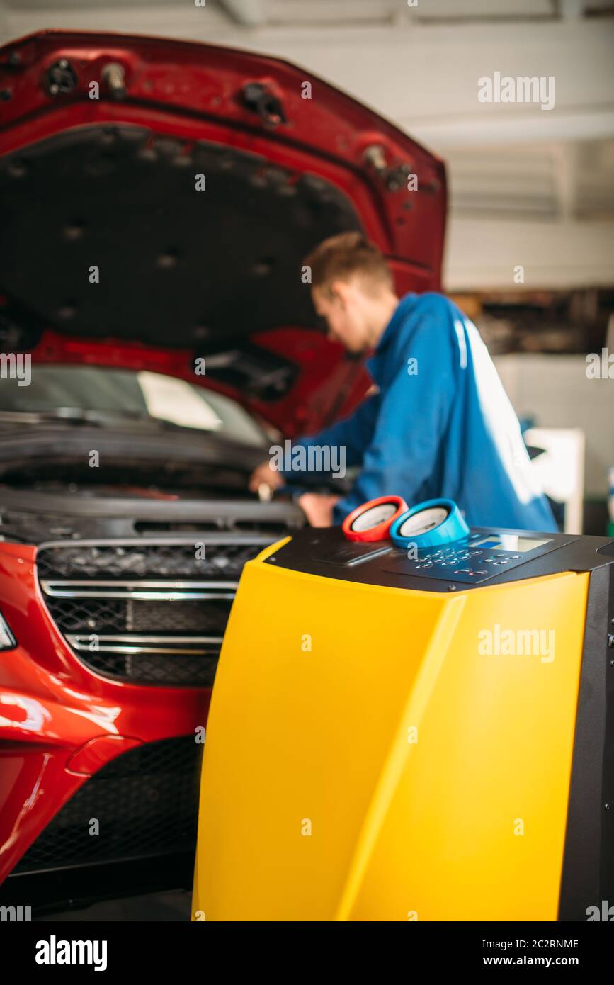 Mechanic connects air conditioning system for diagnosis of freon