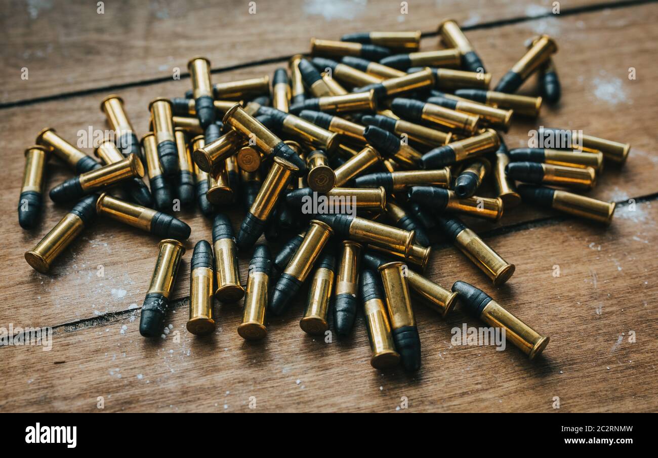 .22 ammunition in pile on a board surrounded by powder Stock Photo