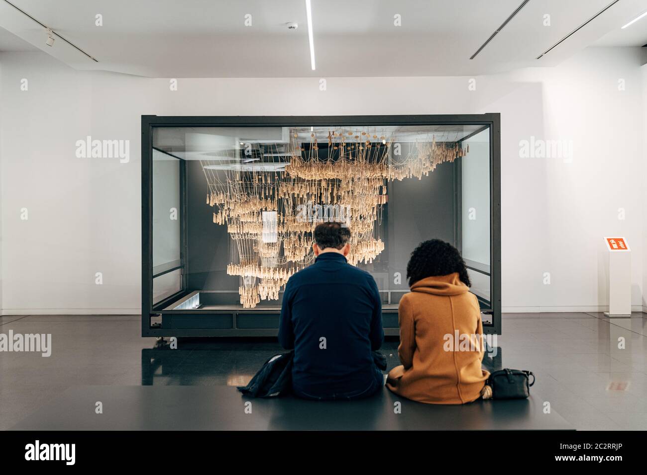 Tourists in the museum look at rope model invented by Gaudi is a way of designing when he built arched locks with help of ordinary ropes and weights Stock Photo