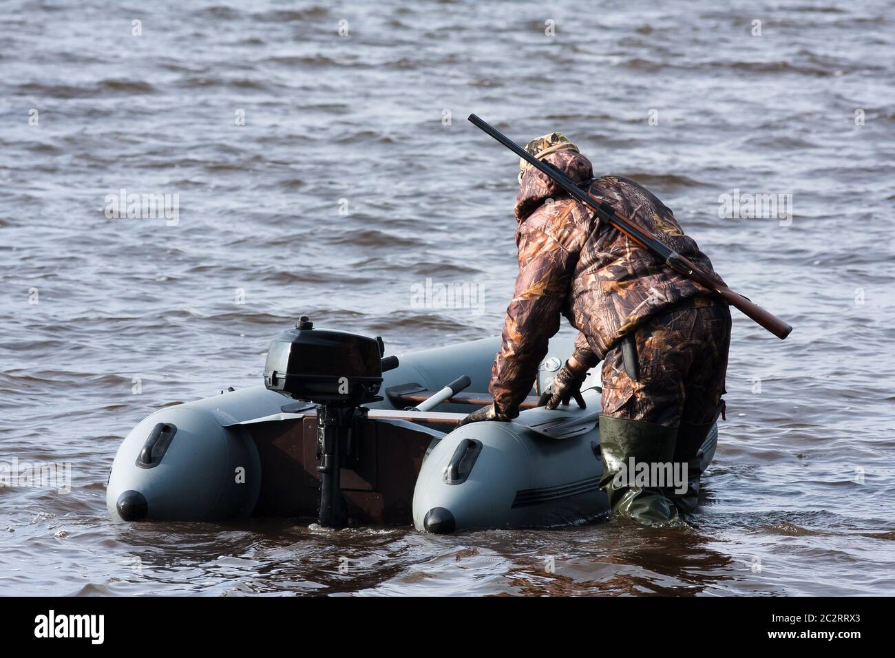 hunter pulls the boat from shoal Stock Photo