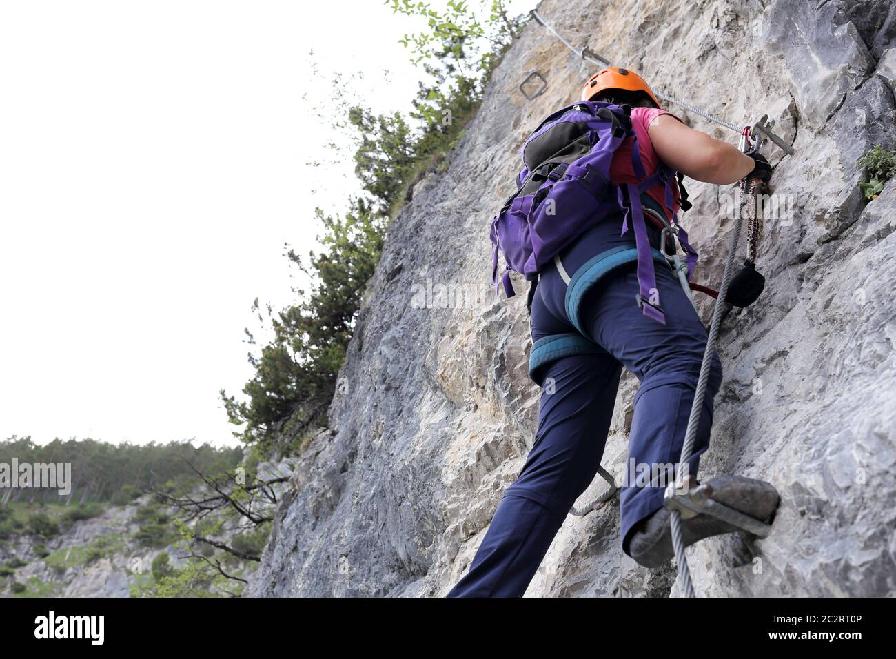 woman is climbing up a rock wall in austria Stock Photo