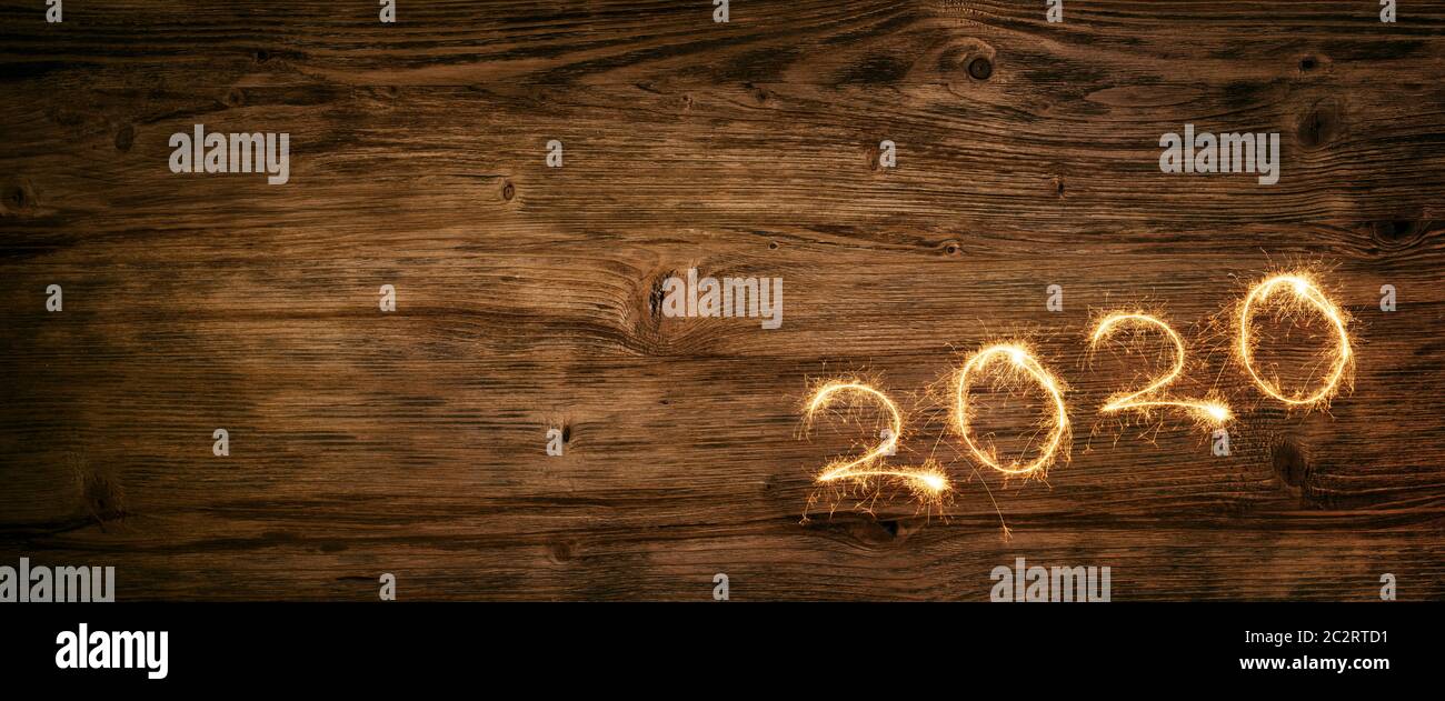 Golden 2020 firework on old dark wooden background for a rustic new ...