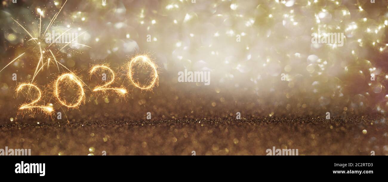 Fireworks 2020 on abstract gold glittering background for a creative new year concept Stock Photo