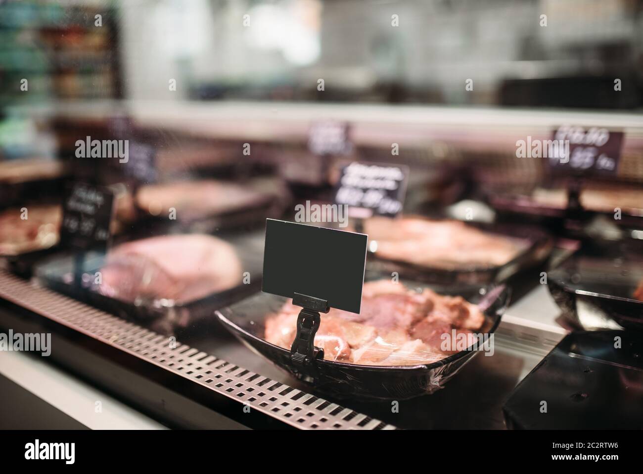Shelf with fresh chilled meat in food market, nobody. Production of