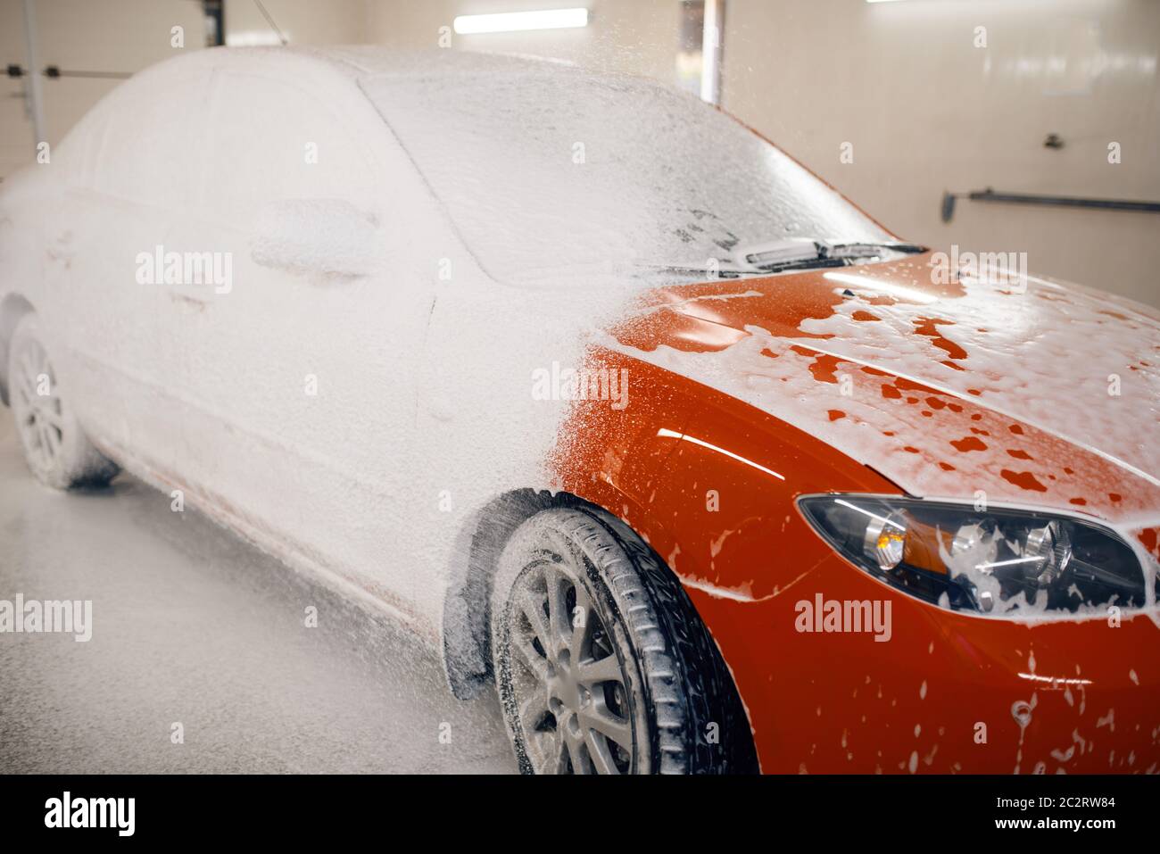 Car wash with foam in car wash station. Carwash. Washing machine at the  station. Car washing concept. Car in foam Stock Photo - Alamy
