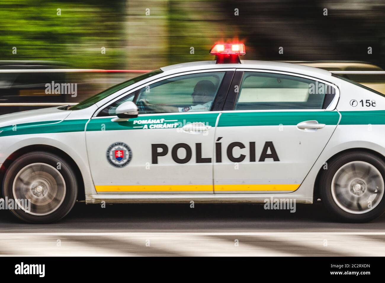 Slovak police officer driving fast police car on street road with blured cars in background with lights on Stock Photo