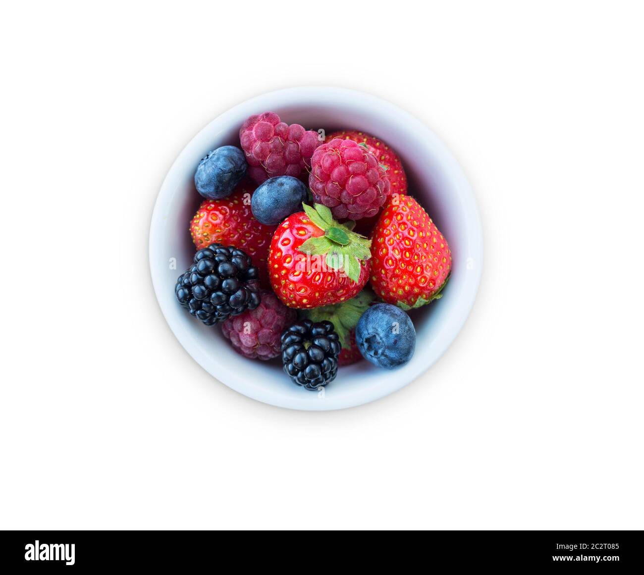 Top view. Fruits and berries in bowl isolated on white background. Ripe raspberries, strawberries, blackberries and blueberries. Background of mix fru Stock Photo