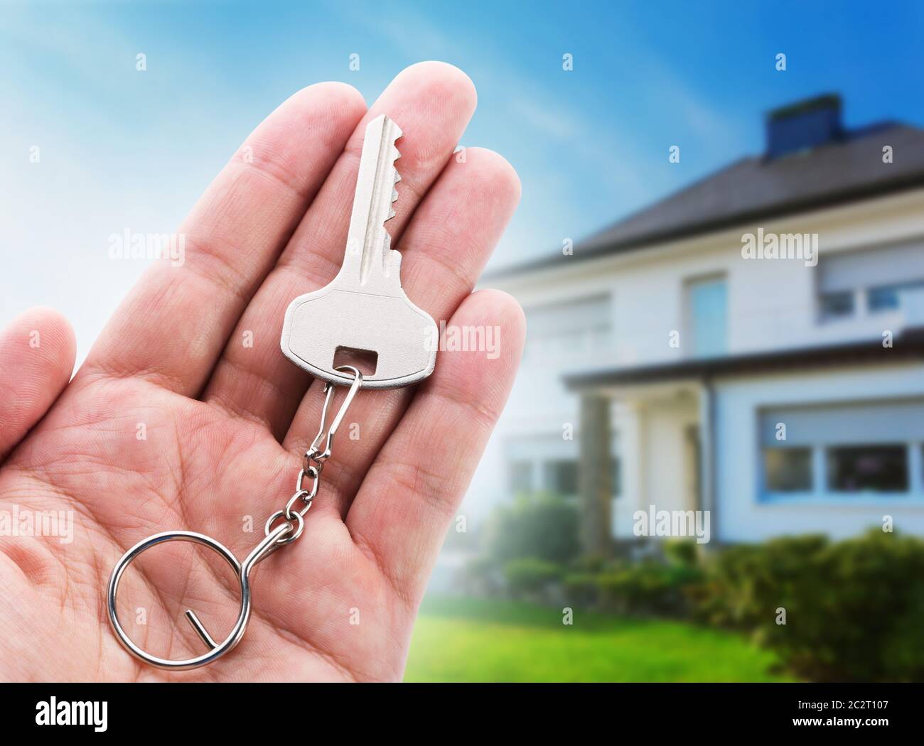 Key in hand against new house Stock Photo - Alamy