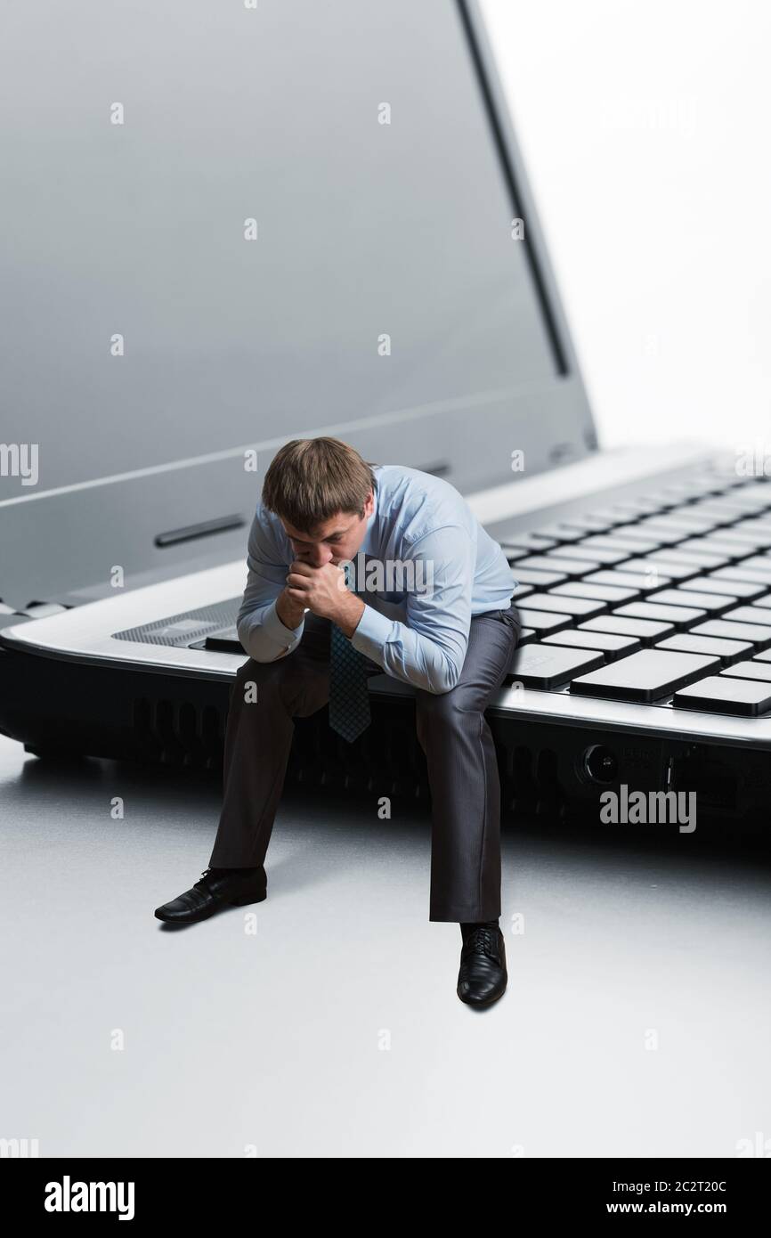 Office employee sitting on laptop thinks Stock Photo