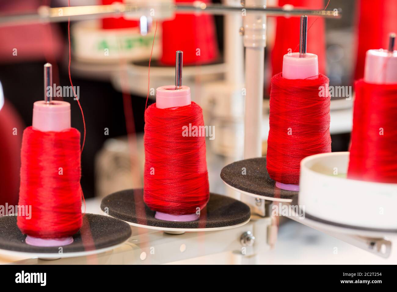 Spools of red threads on sewing machine. Cloth fabric, weaving, textile