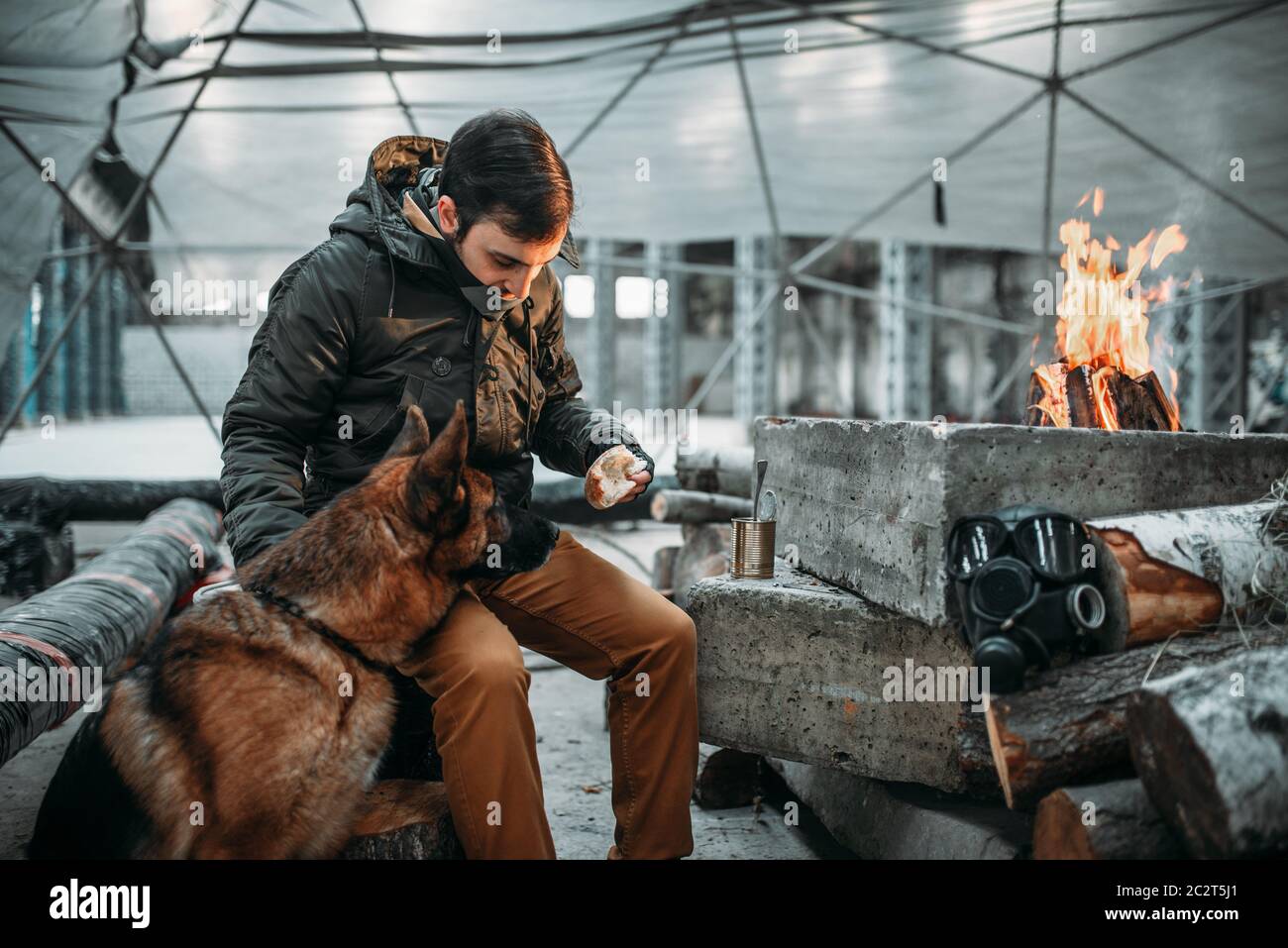 Stalker feeding a dog, apocalypse concept. Post apocalyptic lifestyle on  ruins, doomsday, judgment day Stock Photo - Alamy