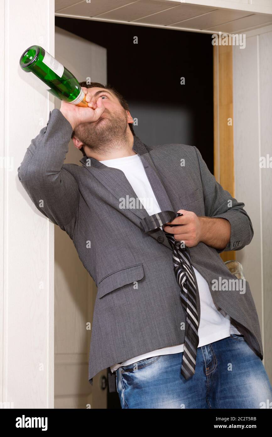 Drunk guy with a bottle of vine indoors Stock Photo Alamy