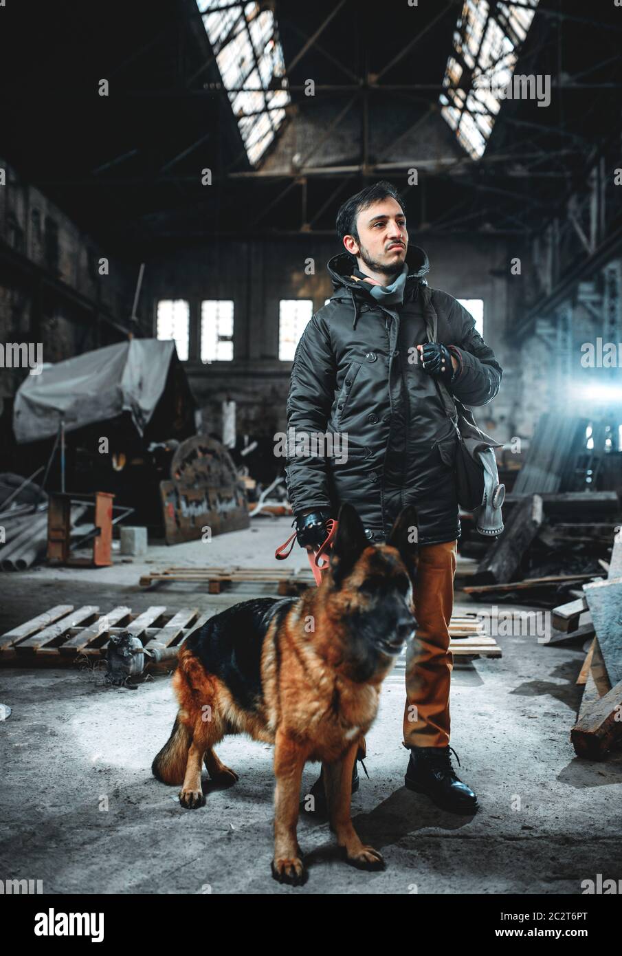 Stalker soldier in gas mask and dog in radioactive zone, friends in post apocalyptic world. Post-apocalypse lifestyle on ruins, doomsday, judgment day Stock Photo